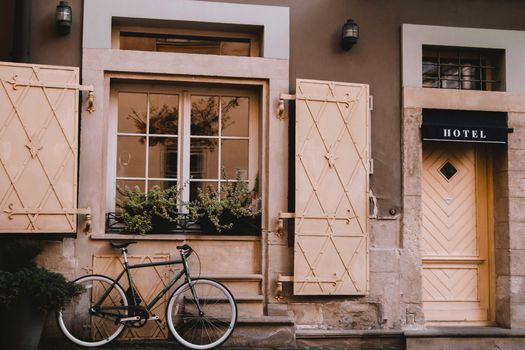 A picturesque street view of a hotel facade featuring classic architecture and an elegant bicycle.