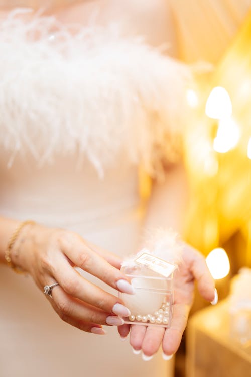 A bride holding a small container of pearls