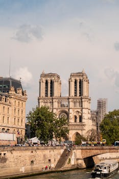 Stunning view of Notre Dame Cathedral in Paris along the River Seine, showcasing iconic gothic architecture.