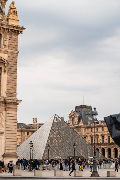 A man is standing in front of the louvre