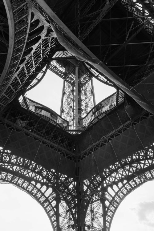 Free Low angle black and white view of the intricate iron structure of the Eiffel Tower in Paris, France. Stock Photo
