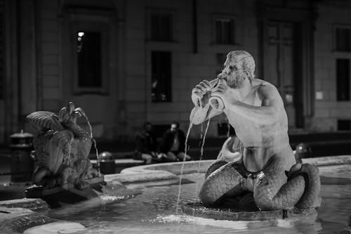 A black and white photo of a statue in a fountain