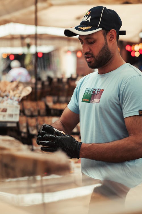 Man in Cap and T-shirt Working in Gloves