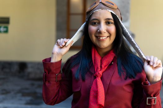 A woman in a red shirt and red scarf is wearing a hat