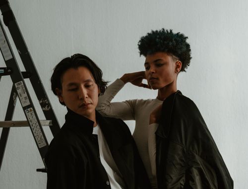 Free A fashionable Asian man and black woman posing in a modern studio setting. Stock Photo