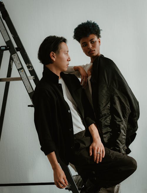 Man Sitting on Ladder and Woman Standing behind