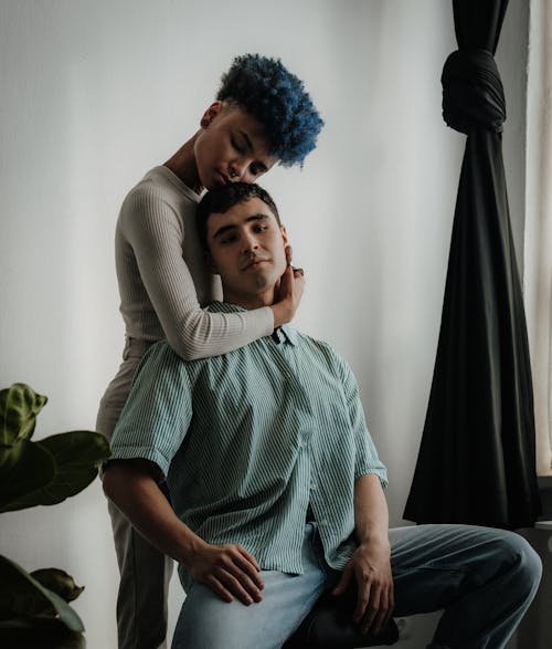 A man and woman sitting on a couch with blue hair