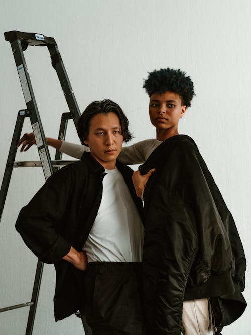 Woman and Man in Jackets Standing by Ladder