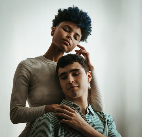 A man and woman with blue hair are hugging