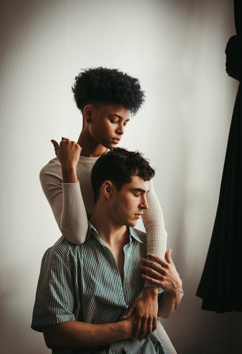 A man and woman sitting on a bed together