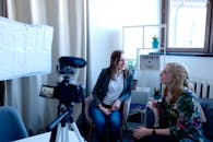 两个女人在现代化的工作区讨论相机设备的设置