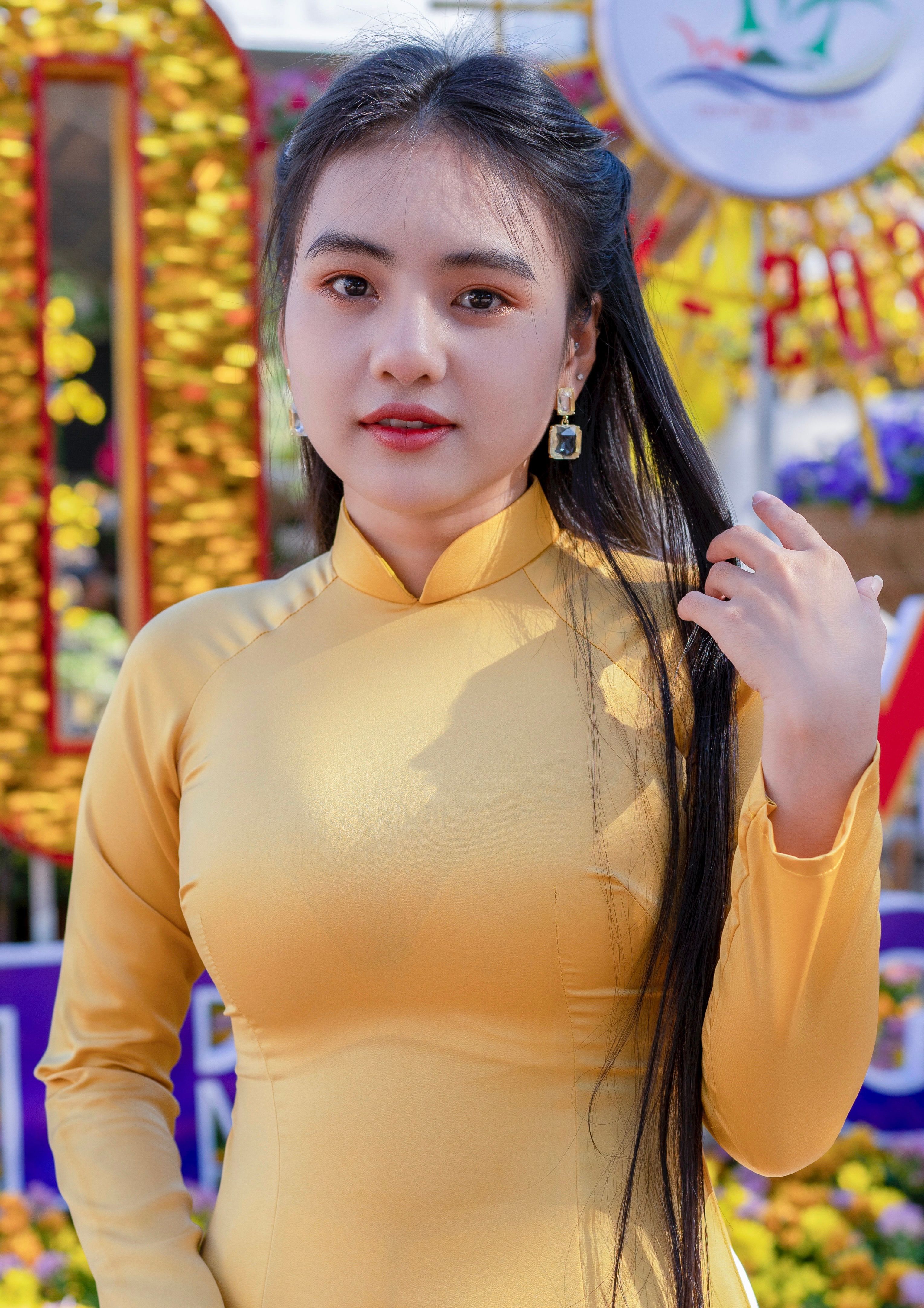 Portrait of a woman in traditional Vietnamese dress with a vibrant outdoor backdrop.