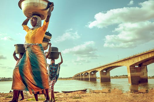 Women carrying goods on their heads by the river near Makurdi Bridge, Nigeria.