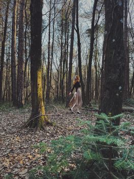 A woman strolls through Istanbul's autumn forest, enveloped in seasonal beauty.