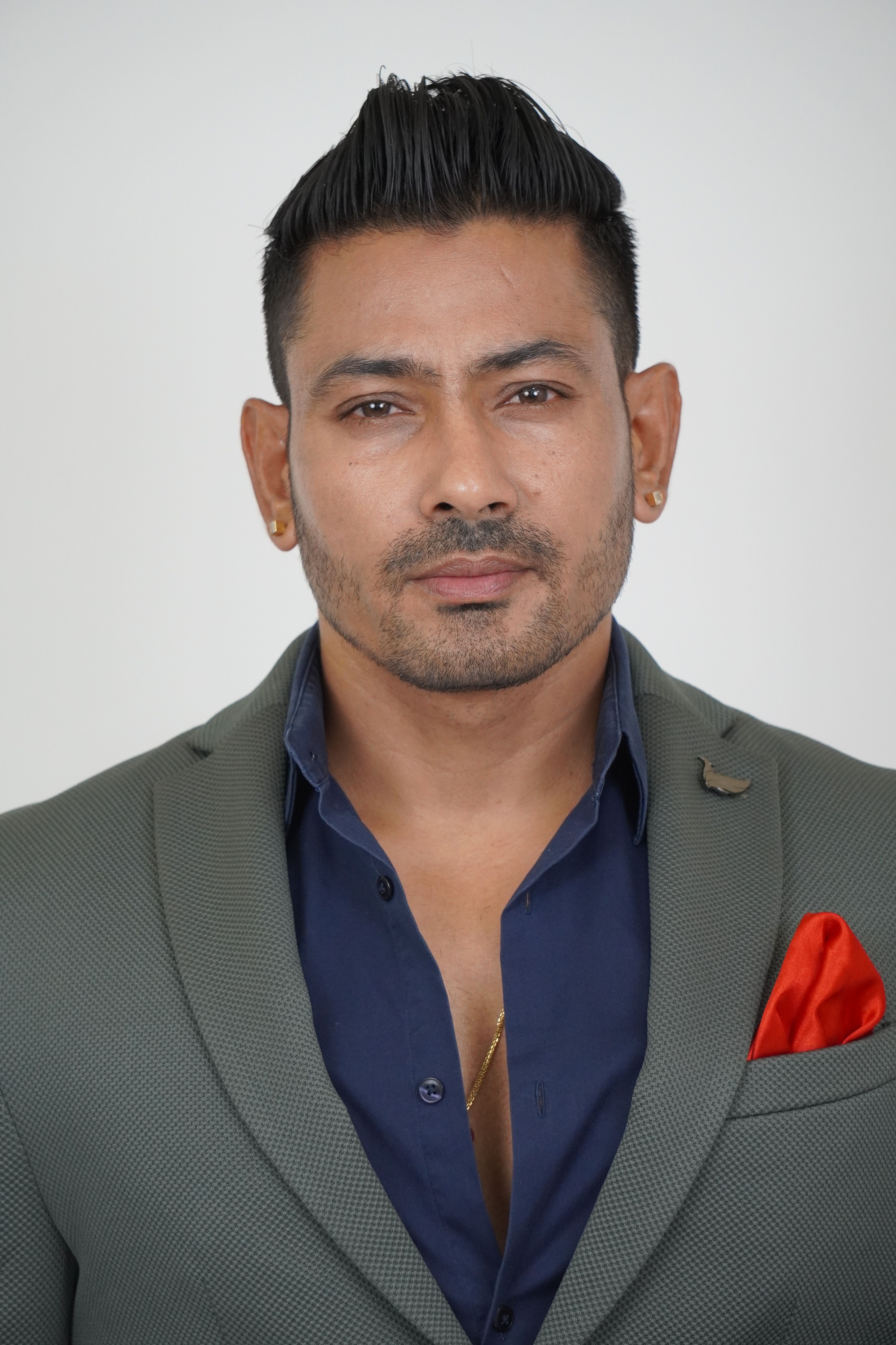Portrait of a confident businessman in a tailored gray suit with a red pocket square.