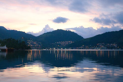 A lake with mountains in the background at sunset