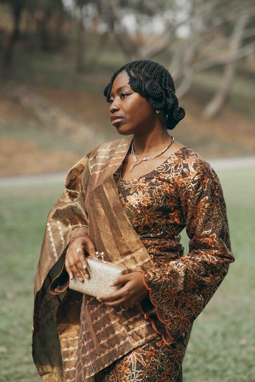 A woman in an african print dress and clutch