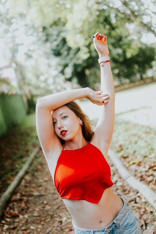 Fotos de stock gratuitas de blusa roja, brazos levantados, de pie