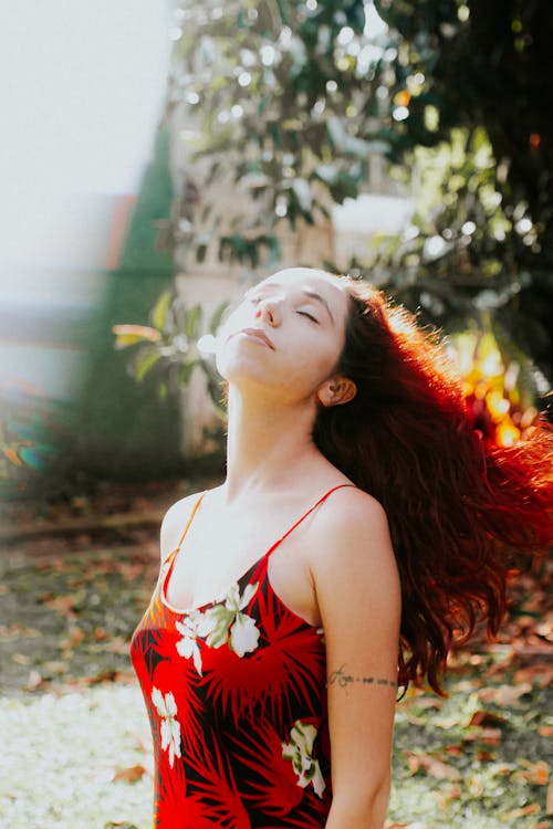 A woman with red hair in a floral dress