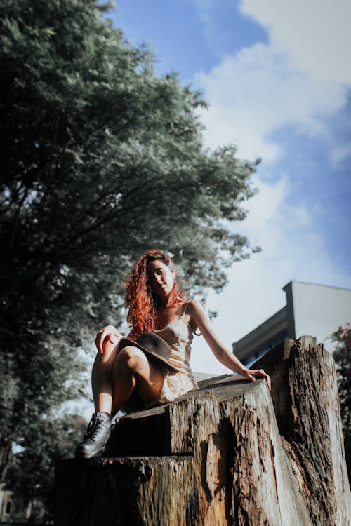A woman sitting on a tree stump