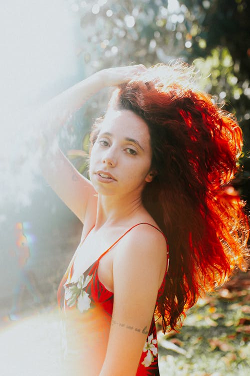 A woman with red hair and a flower dress