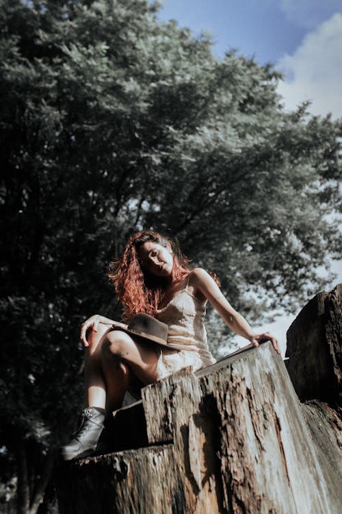 A woman sitting on a tree stump