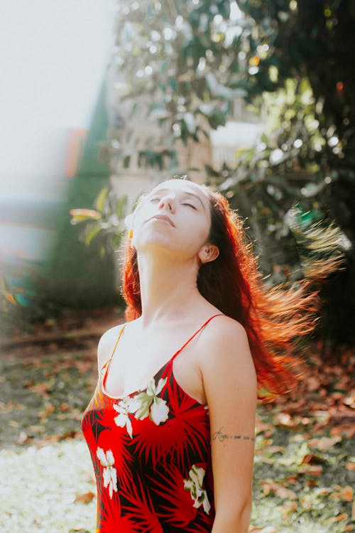 A woman with red hair in a floral dress