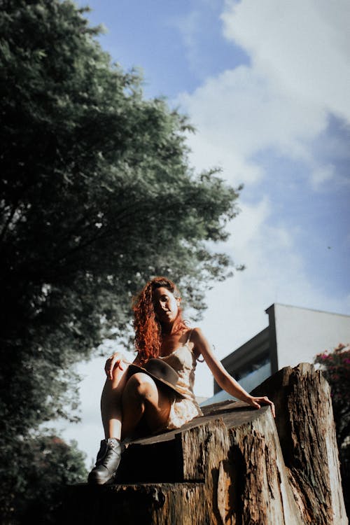 A woman sitting on a tree stump