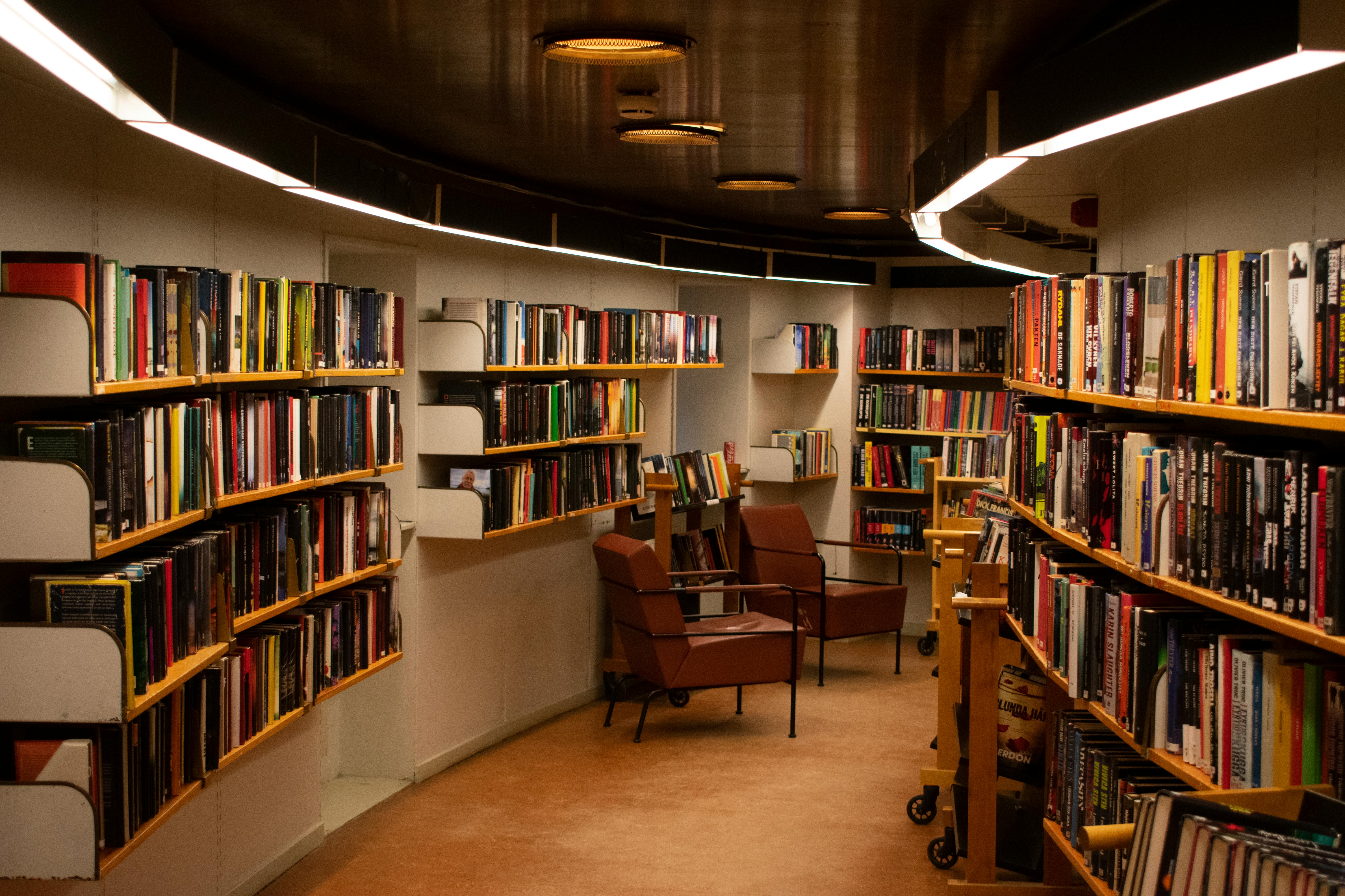 Chair Beside Book Shelves · Free Stock Photo