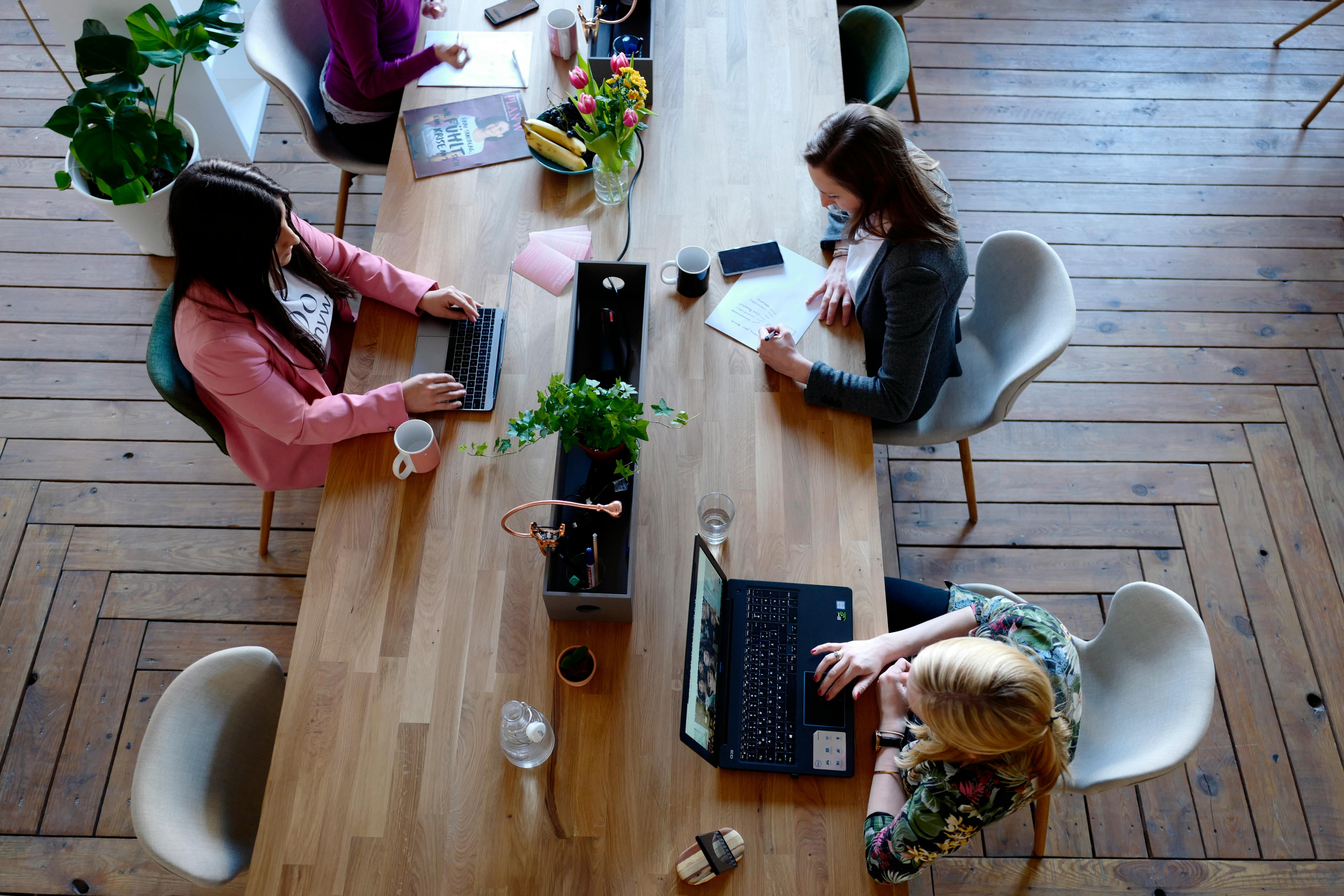 Free Three Woman Sitting on White Chair in Front of Table Stock Photo