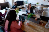 在现代办公环境中，妇女使用笔记本电脑和室内植物来促进团队合作