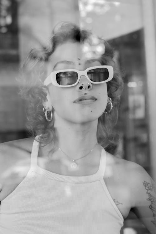 A woman with sunglasses and a tattoo on her arm