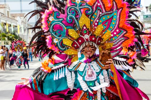 Free A joyful performer in colorful traditional attire during a vibrant street festival parade. Stock Photo