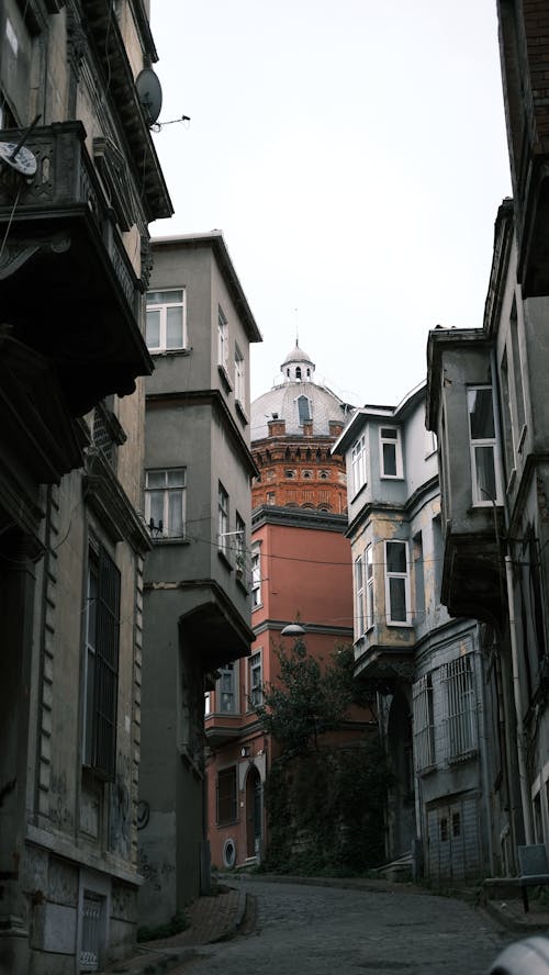 A narrow street with buildings and a clock tower