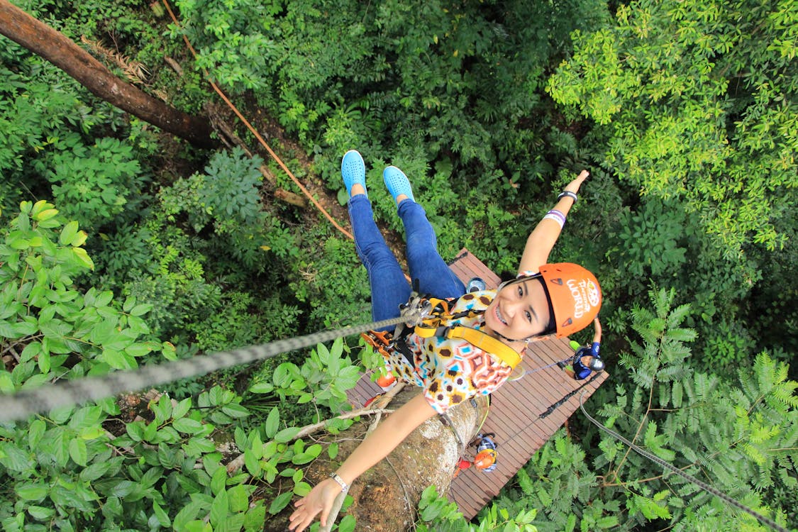 A woman hanging on a zipline rope.