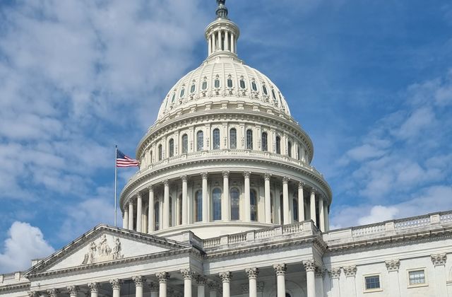 A striking view of the US Capitol dome with flag and blue sky in Washington, DC. — arriving in Dulles
