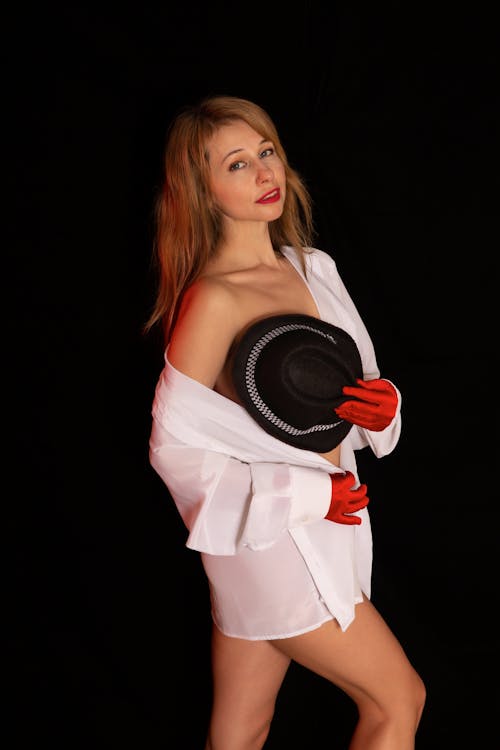 A woman in white gloves and a hat posing