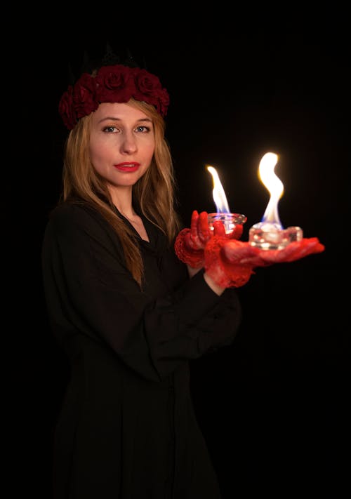 A woman holding two lit candles in her hands