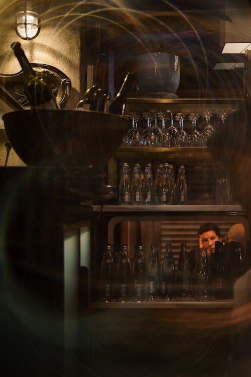 Glasses and Bottles on Shelves behind Bar Window