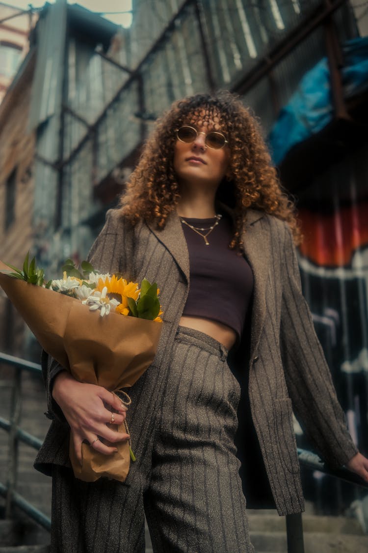 Woman In Suit Standing With Flowers Bouquet