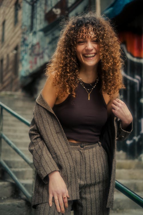A woman with curly hair smiles for the camera