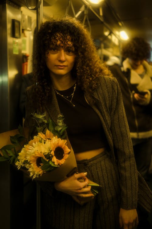 A woman holding flowers on a train