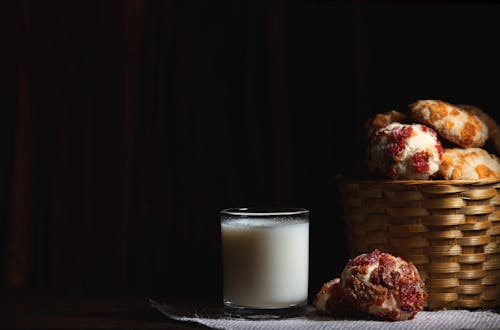 White Pillar Candle Beside Brown Cookies