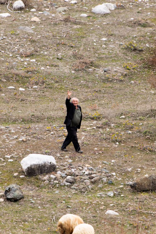 Eldelry Man Walking on Grassland and Waving