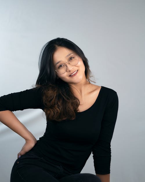 Kostnadsfri bild av asiatisk kvinna, grå bakgrund, hand på höften