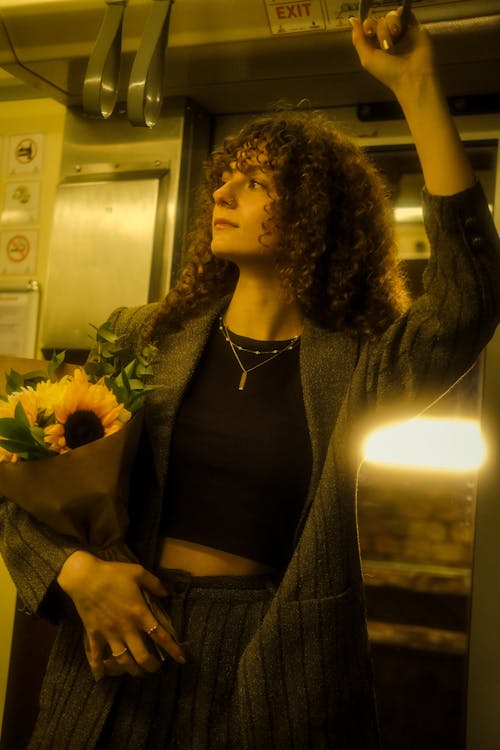 A woman holding a bunch of flowers and a phone