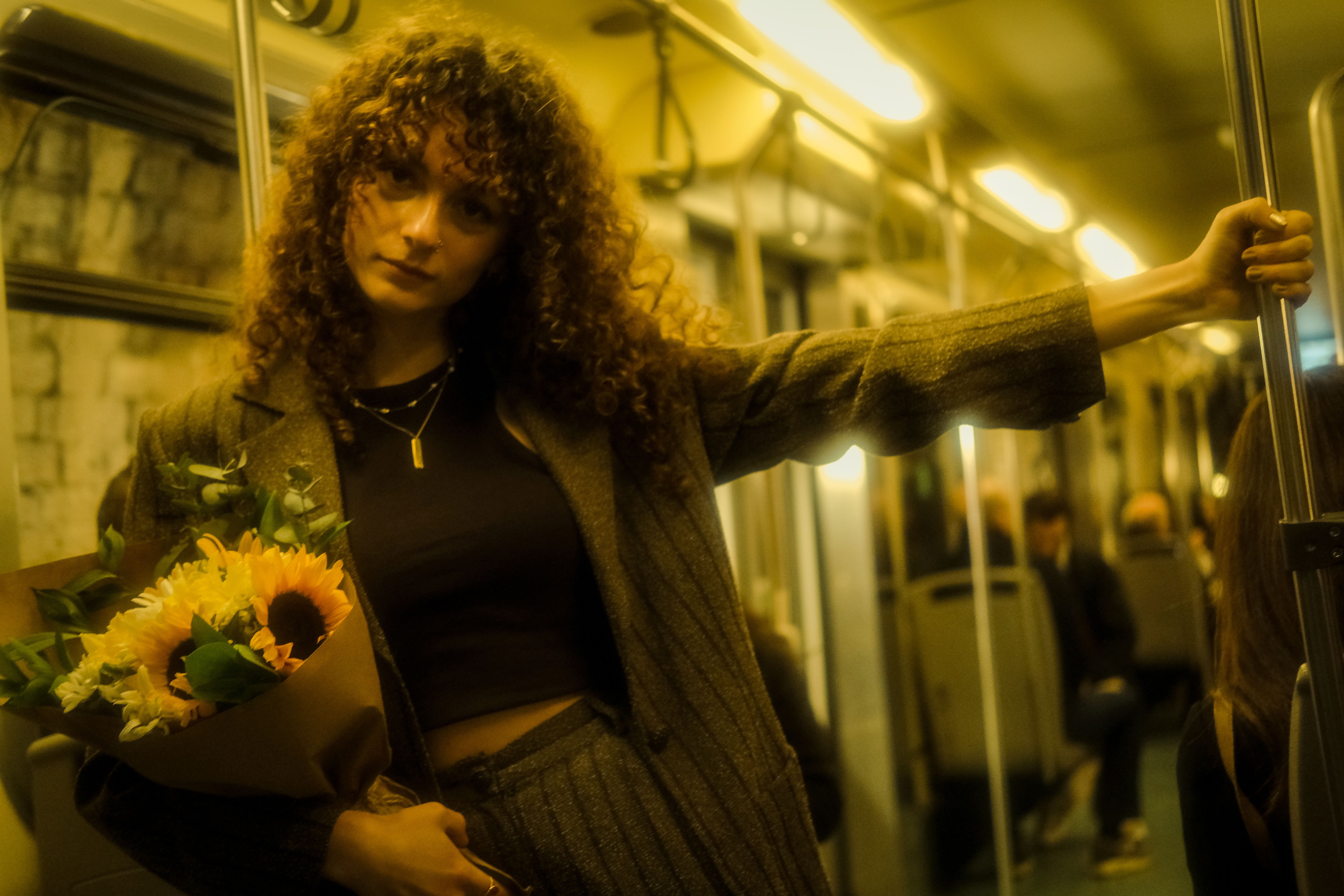 Woman with Flowers Leaning on Handrail on Train · Free Stock Photo