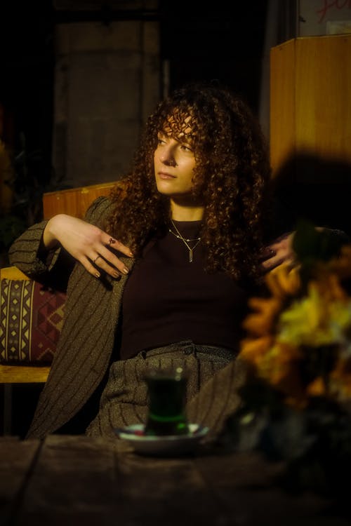 Woman with Curly Hair Sitting in Suit