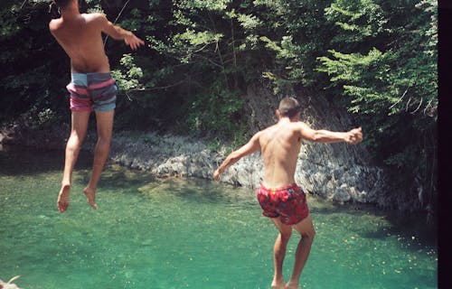 Men Jumping into Lake
