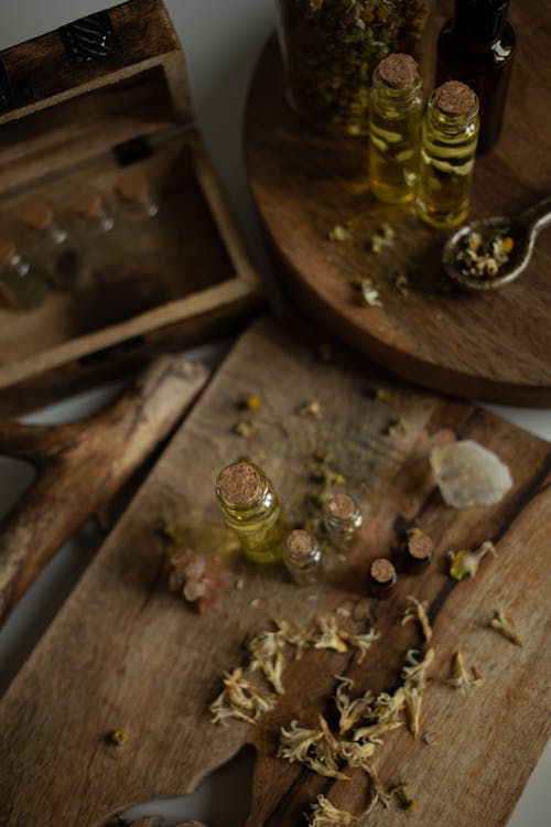 Herbs and Tiny Glass Bottles on Wooden Board